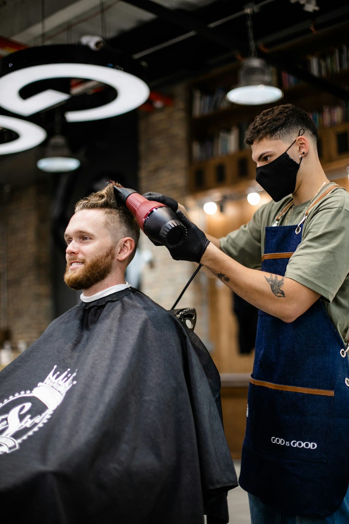 Barber finishing a client's haircut at the barbershop